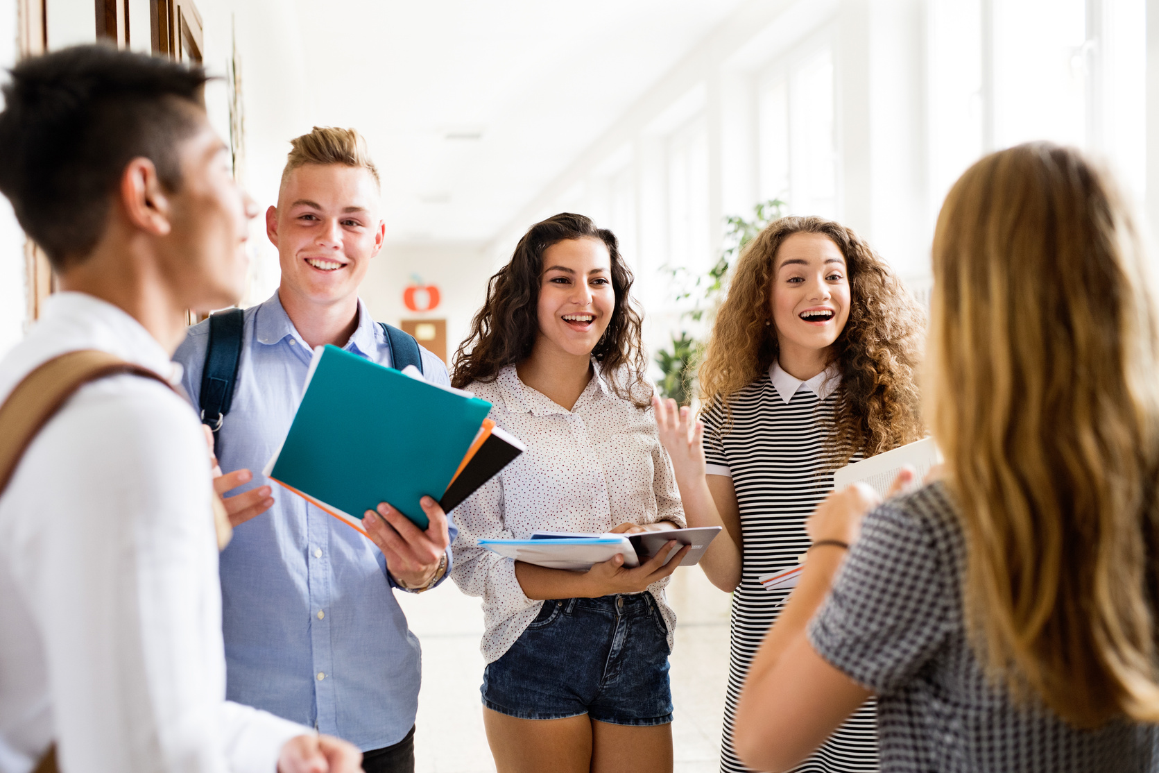 Teenage Students Walking In High School Hall, Talking